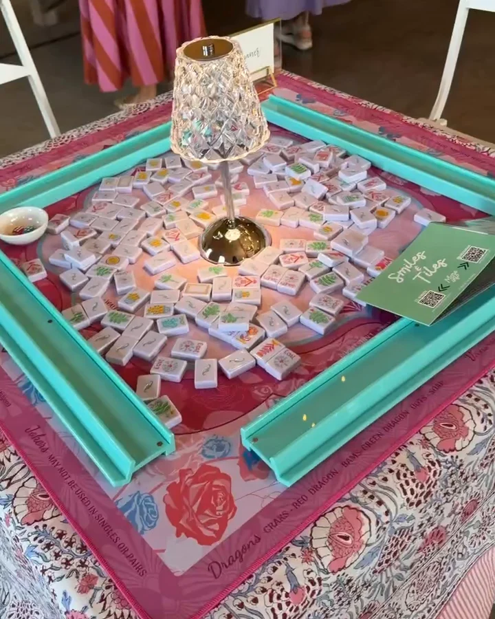 A Barn table set for play: pink and teal mat, a crystal lamp in the middle, tiles washed.